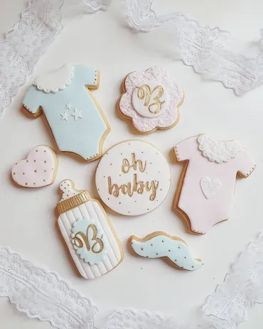 Blue striped round iced biscuits with white and yellow sugar flowers and monogram detail
