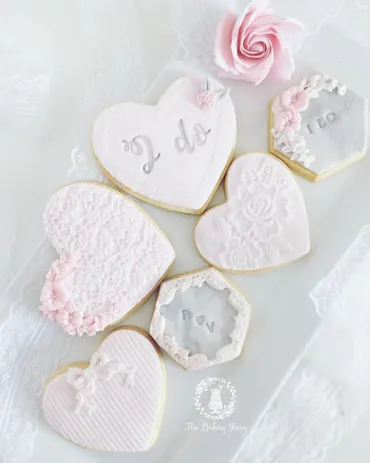 Pink and grey wedding iced biscuits with I do, lace, bow and R&N monogram designs with sugar rose