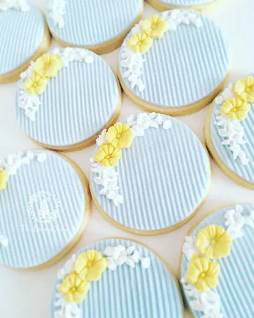 Pink and blue Oh Baby gender neutral baby shower iced biscuits with onesie, baby bottle, B monogram and moustache designs