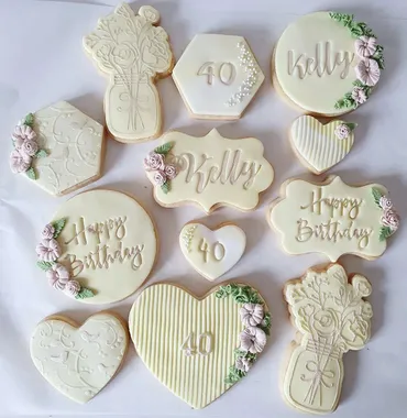 Blue and white Baby Rapaj baby shower iced biscuits with elephant, baby bottle and onesie designs