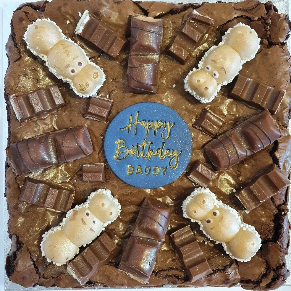 Triple chocolate brownie slab with Milkybar figures, chocolate bars and Happy Birthday Daddy topper
