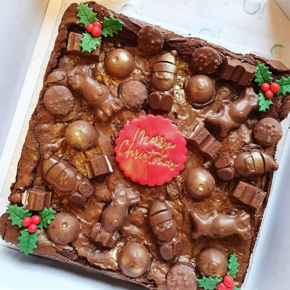 Christmas brownie slab with Maltesers, chocolate Santas, gold baubles and Merry Christmas topper