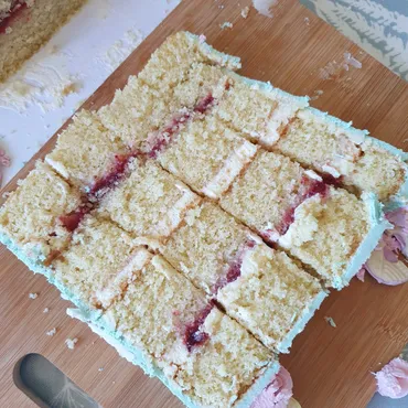 Close-up slice of layered vanilla sponge with strawberry jam and cream filling