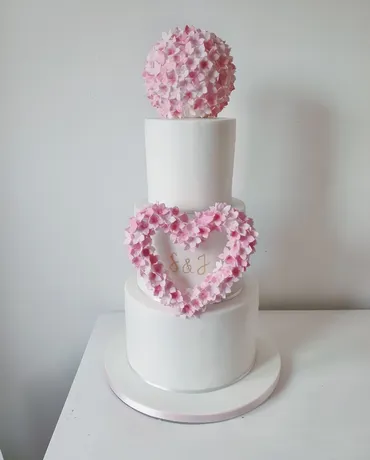 Two-tier grey wedding cake with yellow sugar roses and billy ball flowers