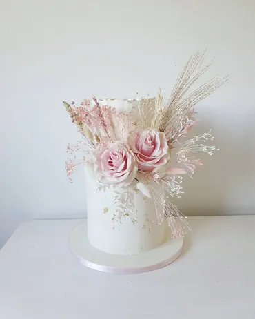 Three-tier ivory geometric wedding cake with eucalyptus greenery and gold Mr & Mrs topper