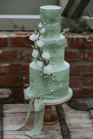Wedding donut tower with chocolate and vanilla glazed donuts, white roses and gold leaf detail on a tiered stand