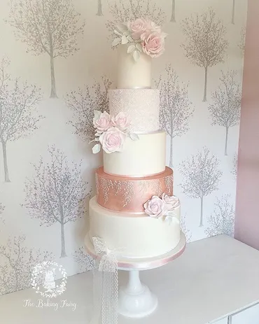 Four-tier white wedding cake with mint chevron tier, silver ribbon and blush roses and butterfly topper