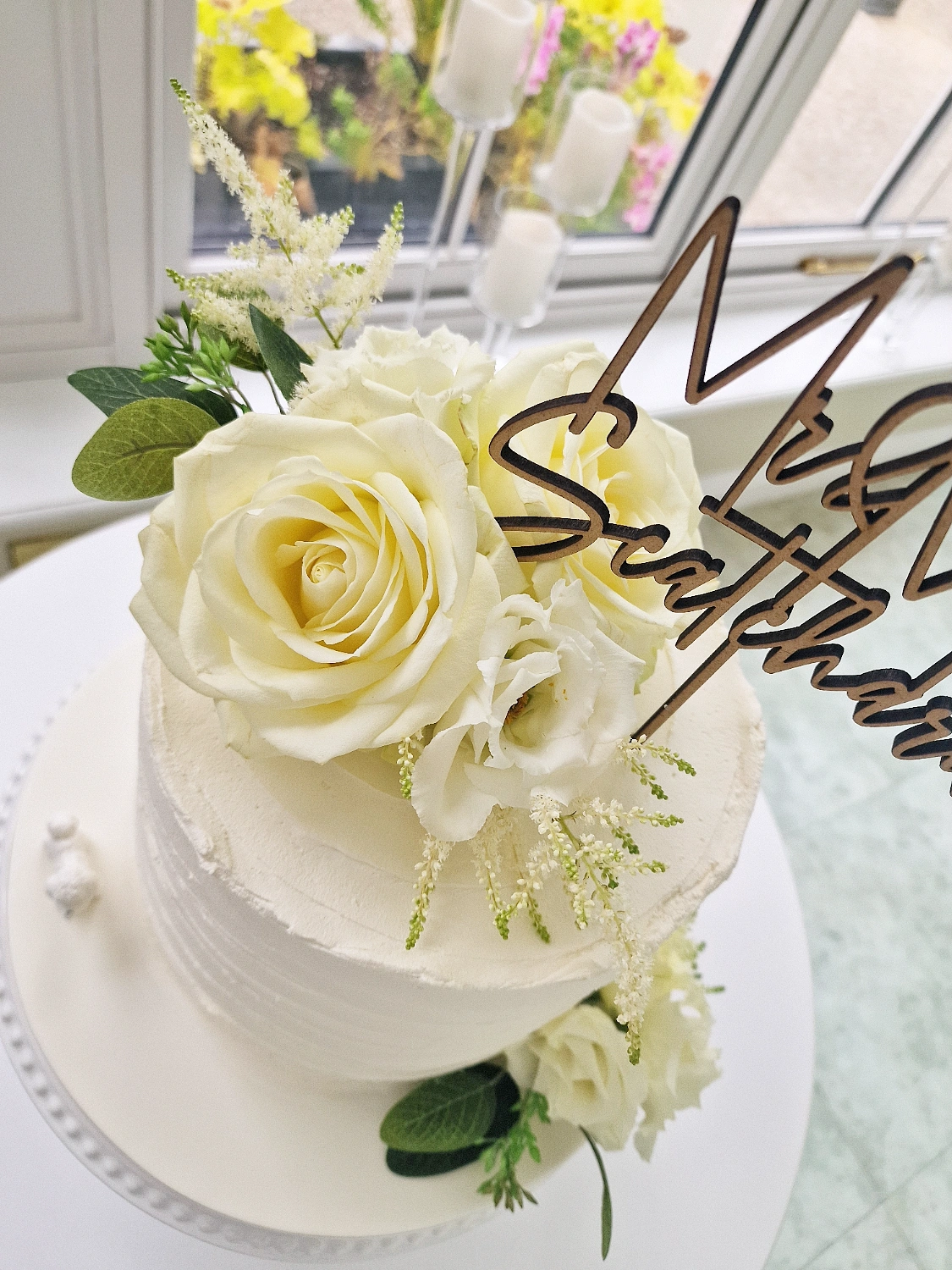 White wedding cake with fresh white roses and personalised wooden topper