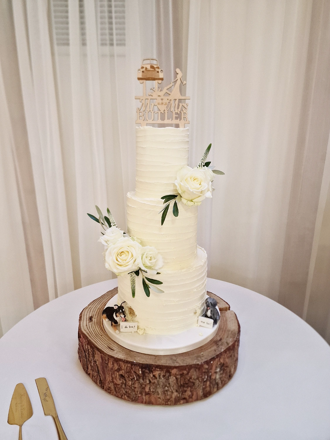 Three-tier textured white wedding cake with white roses and Mr & Mrs Butler topper